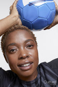 Studio portrait of female soccer player with ball