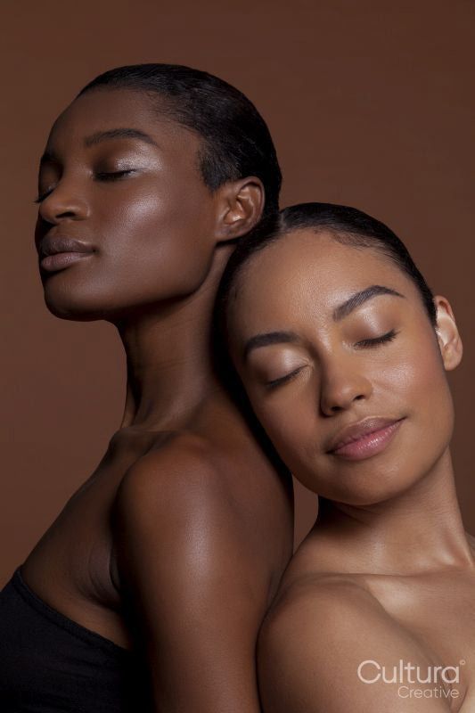Young women standing back to back