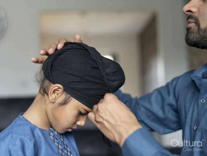Father wrapping turban around son's head