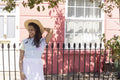 Smiling young woman in sun hat standing in street
