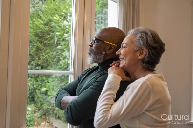 Senior couple looking out living room window