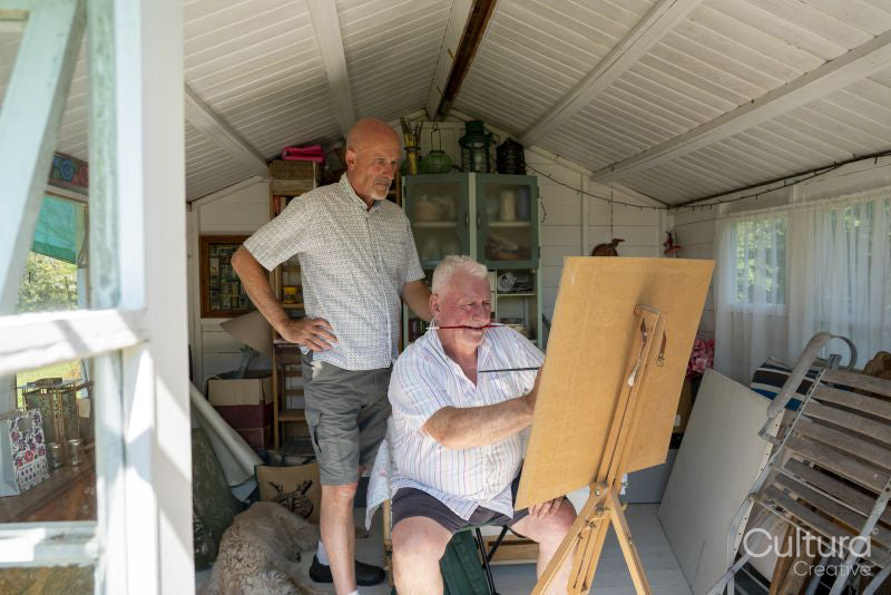Senior male couple painting at home