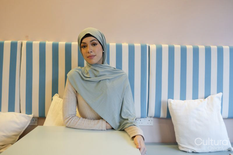 Portrait of young woman in hijab sitting in cafe