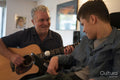 Father playing guitar with disabled son