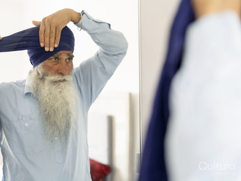 Senior man wrapping turban around head
