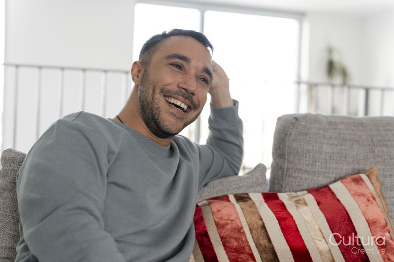 Smiling mature man relaxing on sofa at home