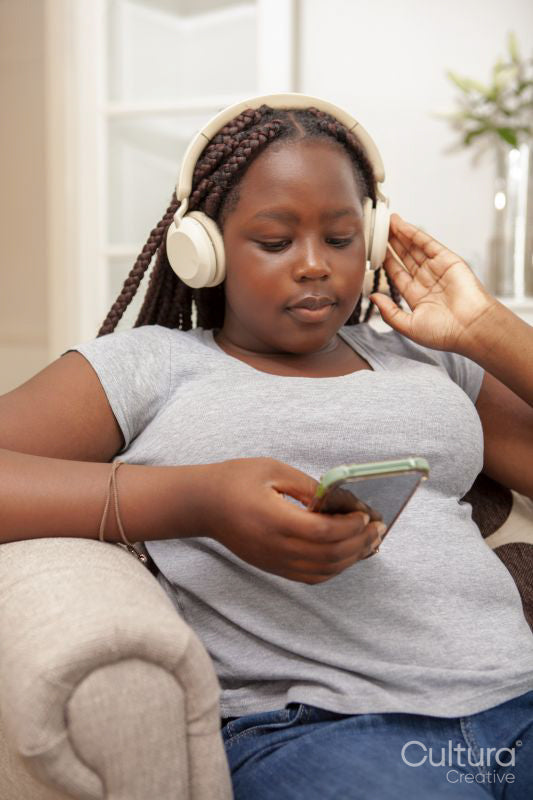 Girl sitting on sofa and listening to music
