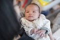 Grandmother holding newborn granddaughter in arms