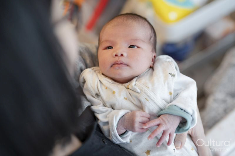 Grandmother holding newborn granddaughter in arms