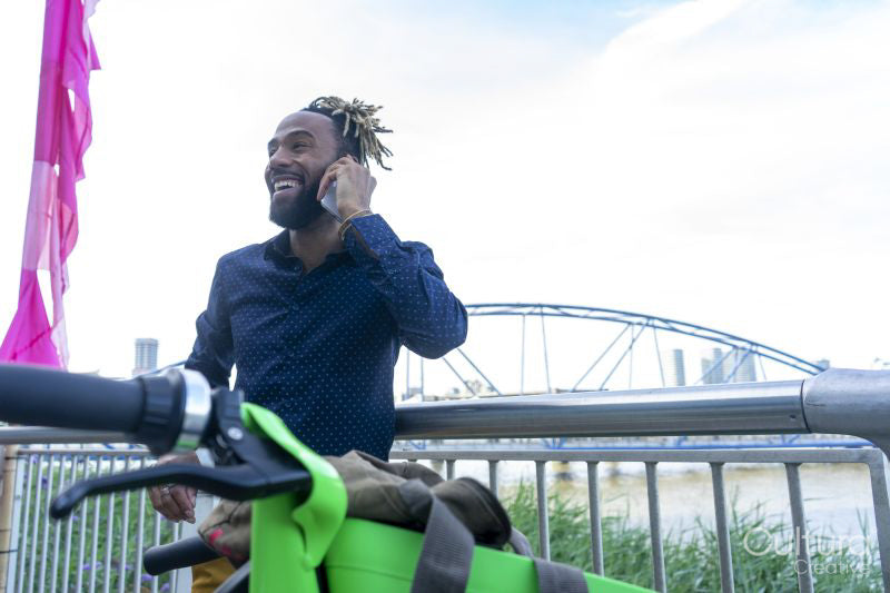 Businessman standing by rental bicycle and talking on phone