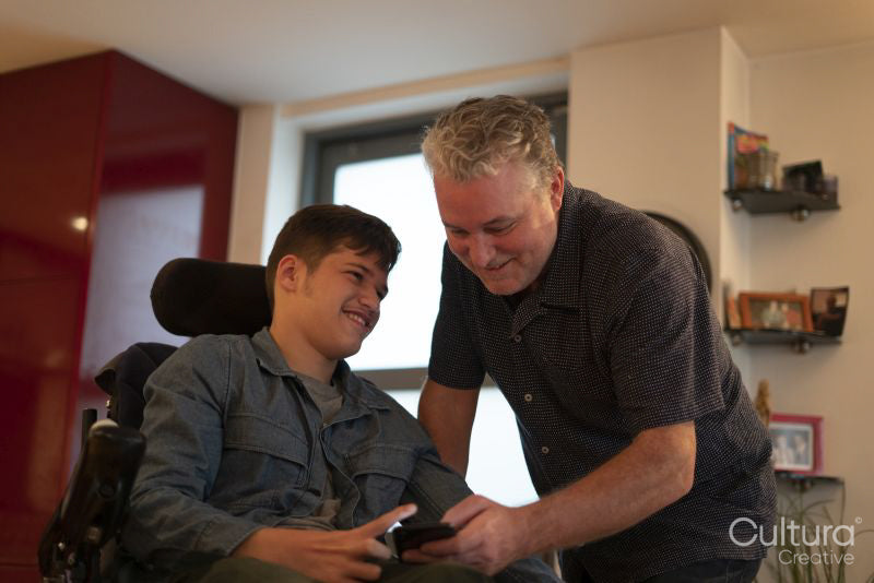 Father spending time with disabled son at home
