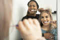 Two young women brushing teeth together