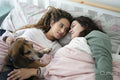 Two women and dog in bed