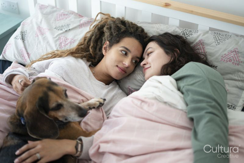 Two women and dog in bed