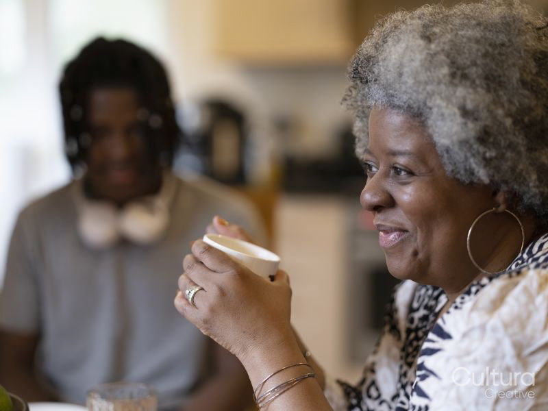 Smiling woman holding cup at home