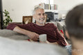 Smiling male couple relaxing on sofa at home