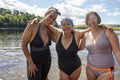 Smiling female friends standing in lake, Yorkshire, UK