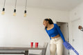Woman cheering friends during beer pong at home party