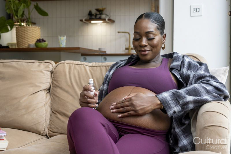 Pregnant woman applying moisturizer on belly