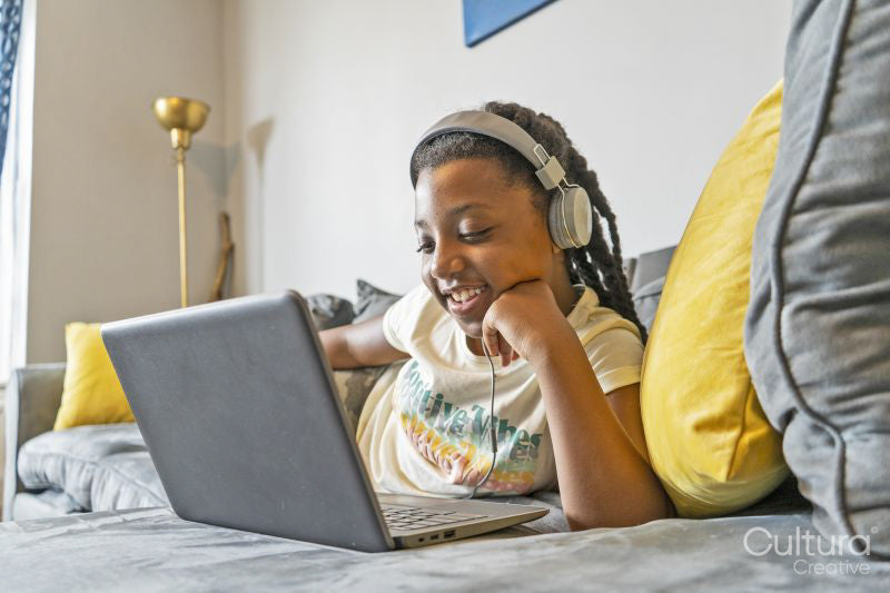 Girl using laptop on sofa