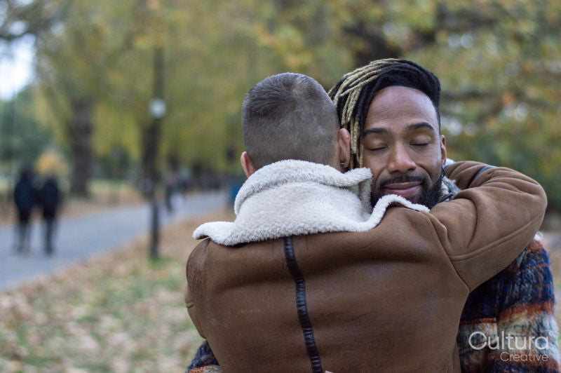 Mid adult men embracing in park