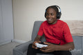 Smiling teenage boy playing video game at home