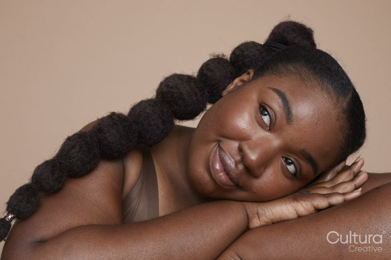 Studio shot of smiling young woman with braided hair