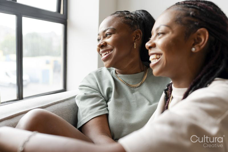 Portrait of happy couple looking through window at home