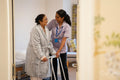 Nurse helping senior lady in her room at nursing home