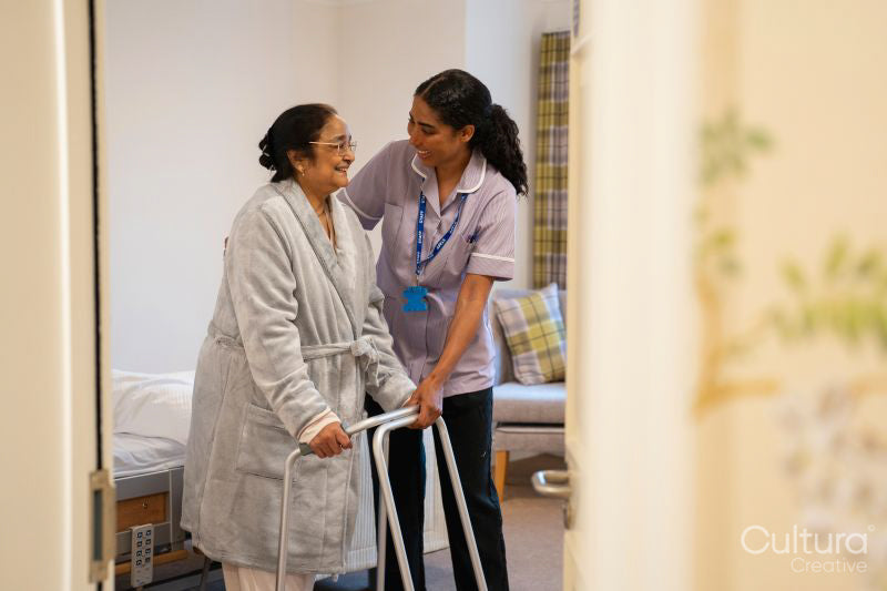 Nurse helping senior lady in her room at nursing home