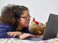 Girl with Down Syndrome using laptop at home