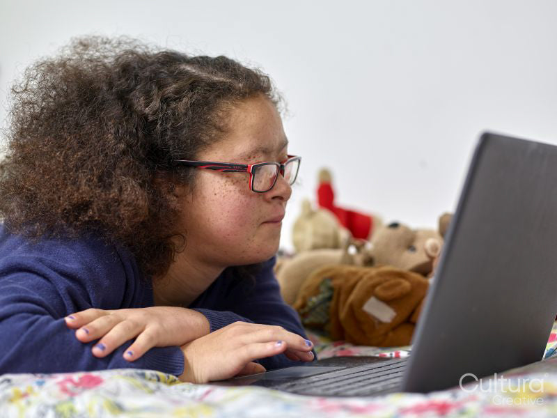 Girl with Down Syndrome using laptop at home