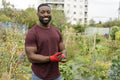 Portrait of smiling man standing in urban vegetable garden