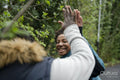 Mother and daughter giving high-five during walk in park