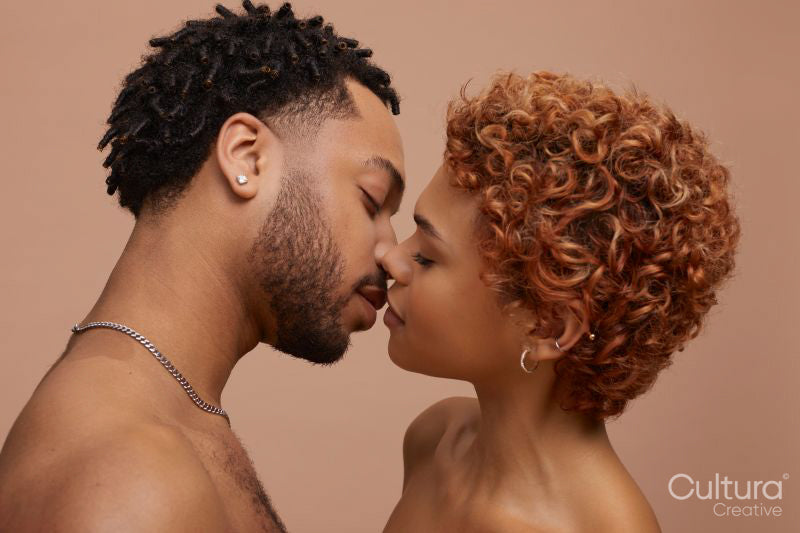 Studio portrait of happy young couple kissing
