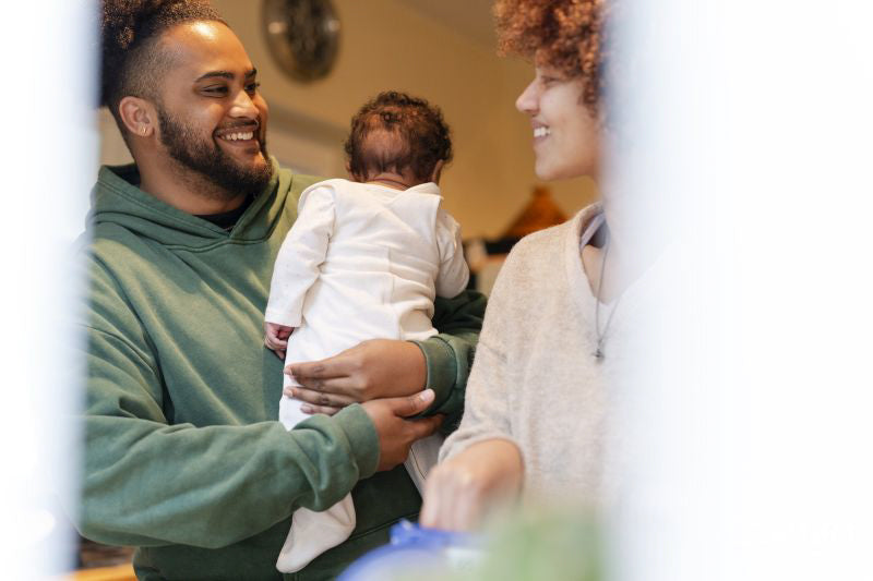 Smiling parents with baby daughter at home
