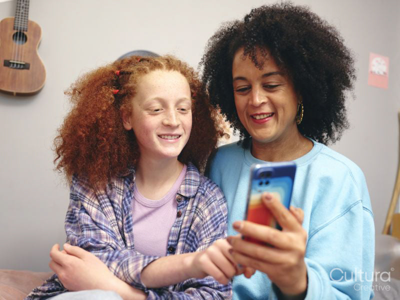 Mother and daughter looking at smart phone