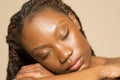 Studio shot of woman with braided hair and eyes closed
