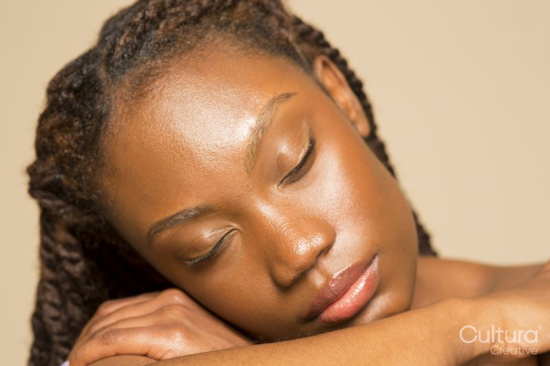 Studio shot of woman with braided hair and eyes closed
