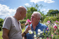 Senior male couple smelling flowers