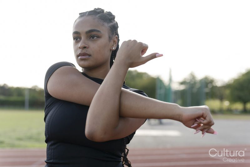 Female athlete stretching arms before training