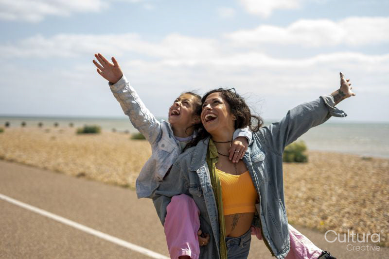 Smiling mother giving daughter piggyback ride