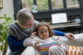 Mother assisting daughter using digital tablet at home