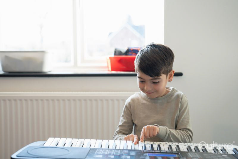 Boy playing music keyboard at home