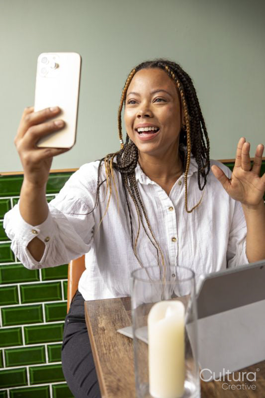 Smiling woman having video call at cafe table
