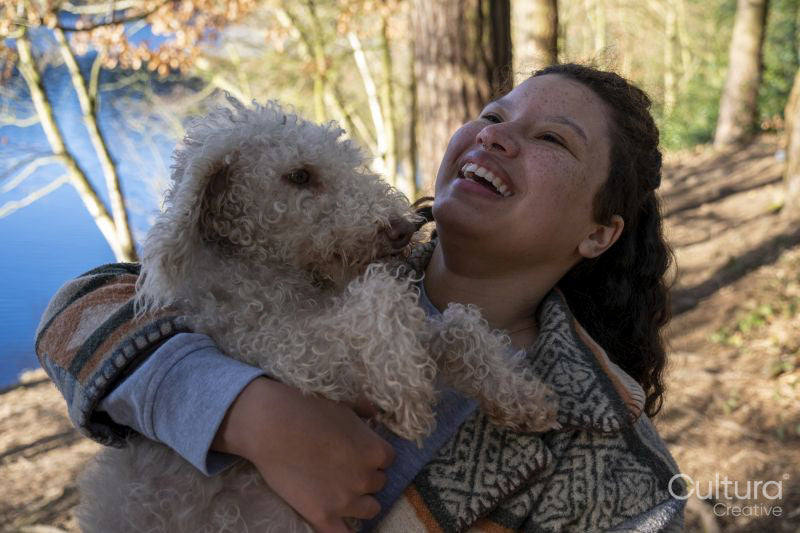 Smiling young woman hugging dog