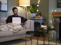 Young man relaxing on sofa with digital tablet