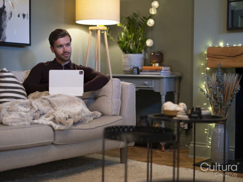 Young man relaxing on sofa with digital tablet