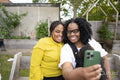 Grandmother with adult daughter and baby grandson taking selfie