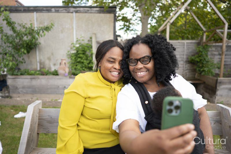 Grandmother with adult daughter and baby grandson taking selfie